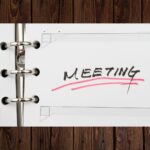 paper planner book with word meeting underlined